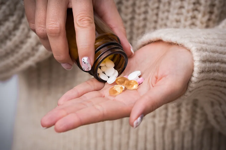 Person taking vitamin K2 supplement
